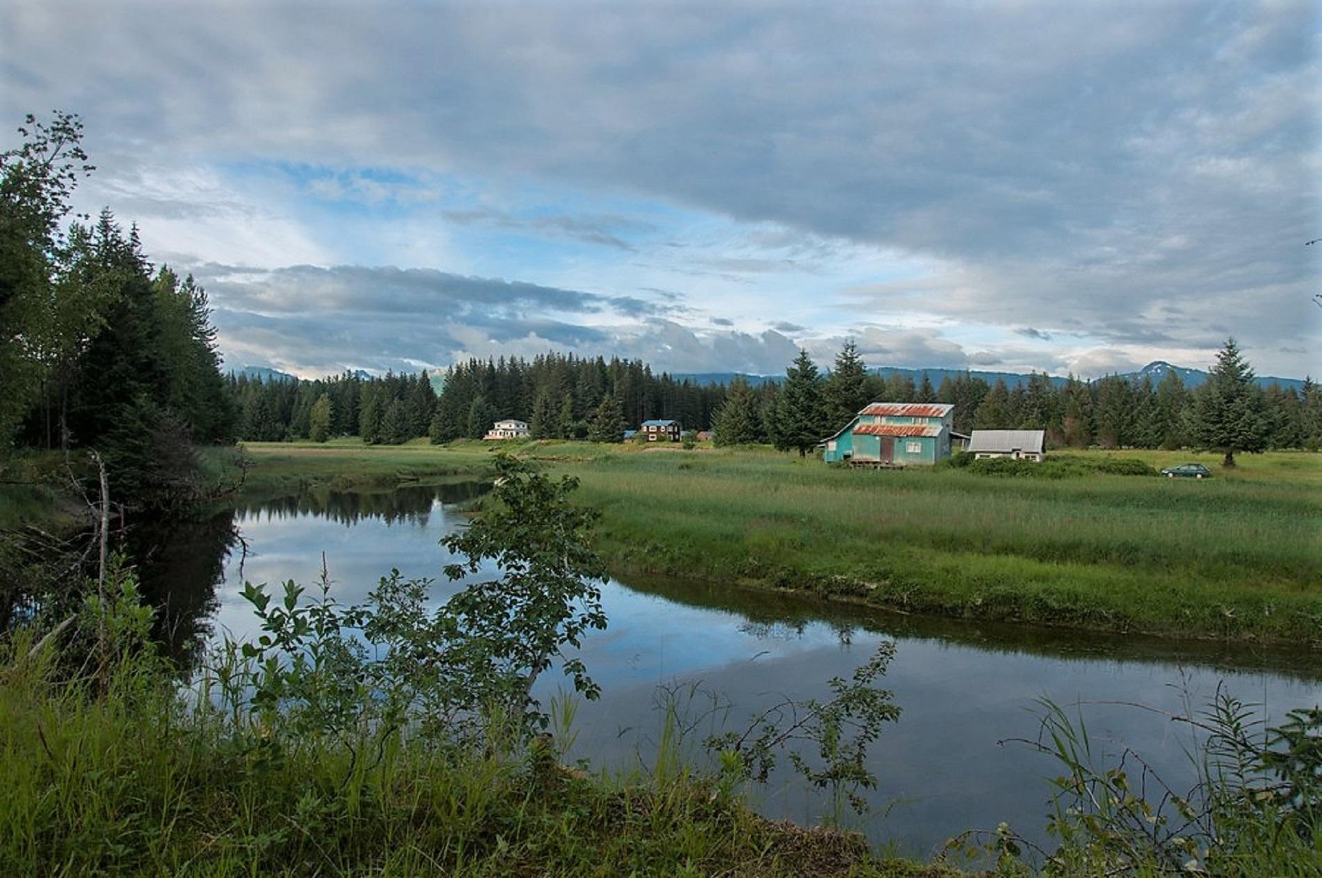 houses along a grassy riverbank