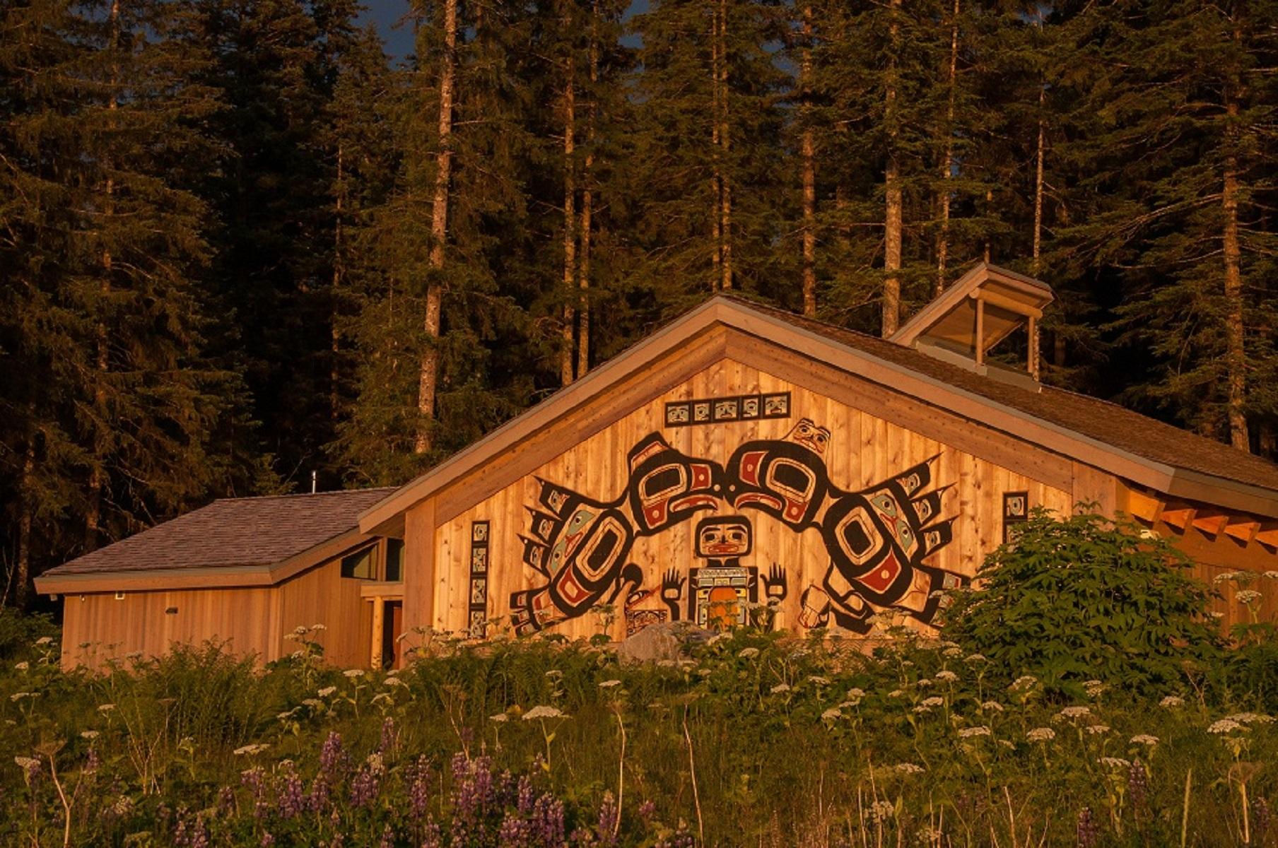 a large building with traditional alaska native carvings on the front at sunset