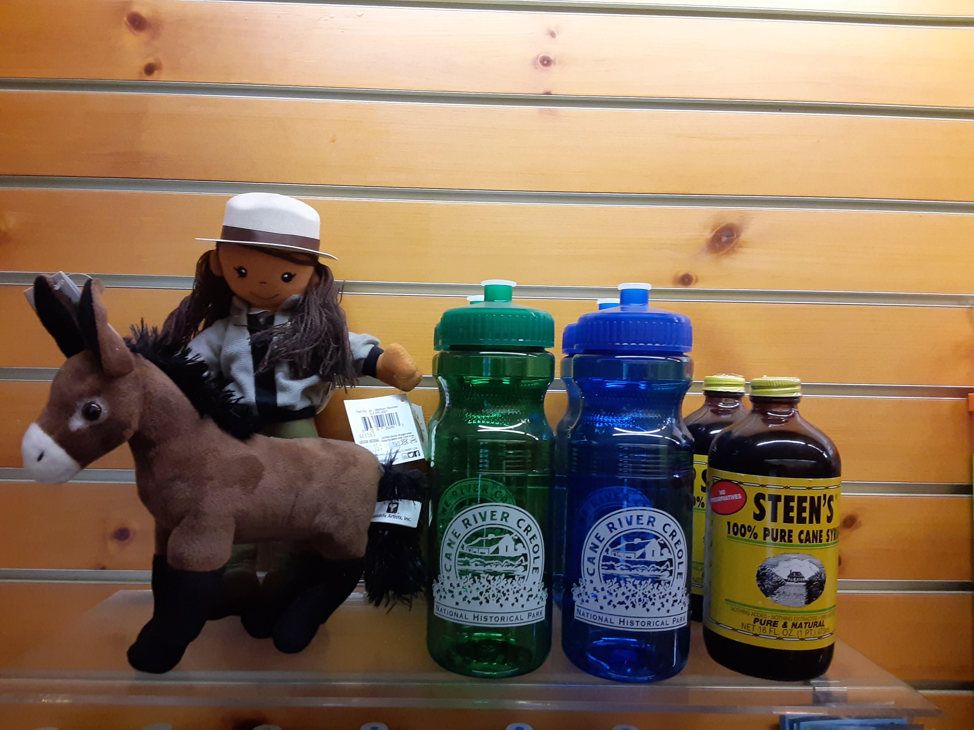 A display of items for purchase including toys, water bottles, and cane syrup.