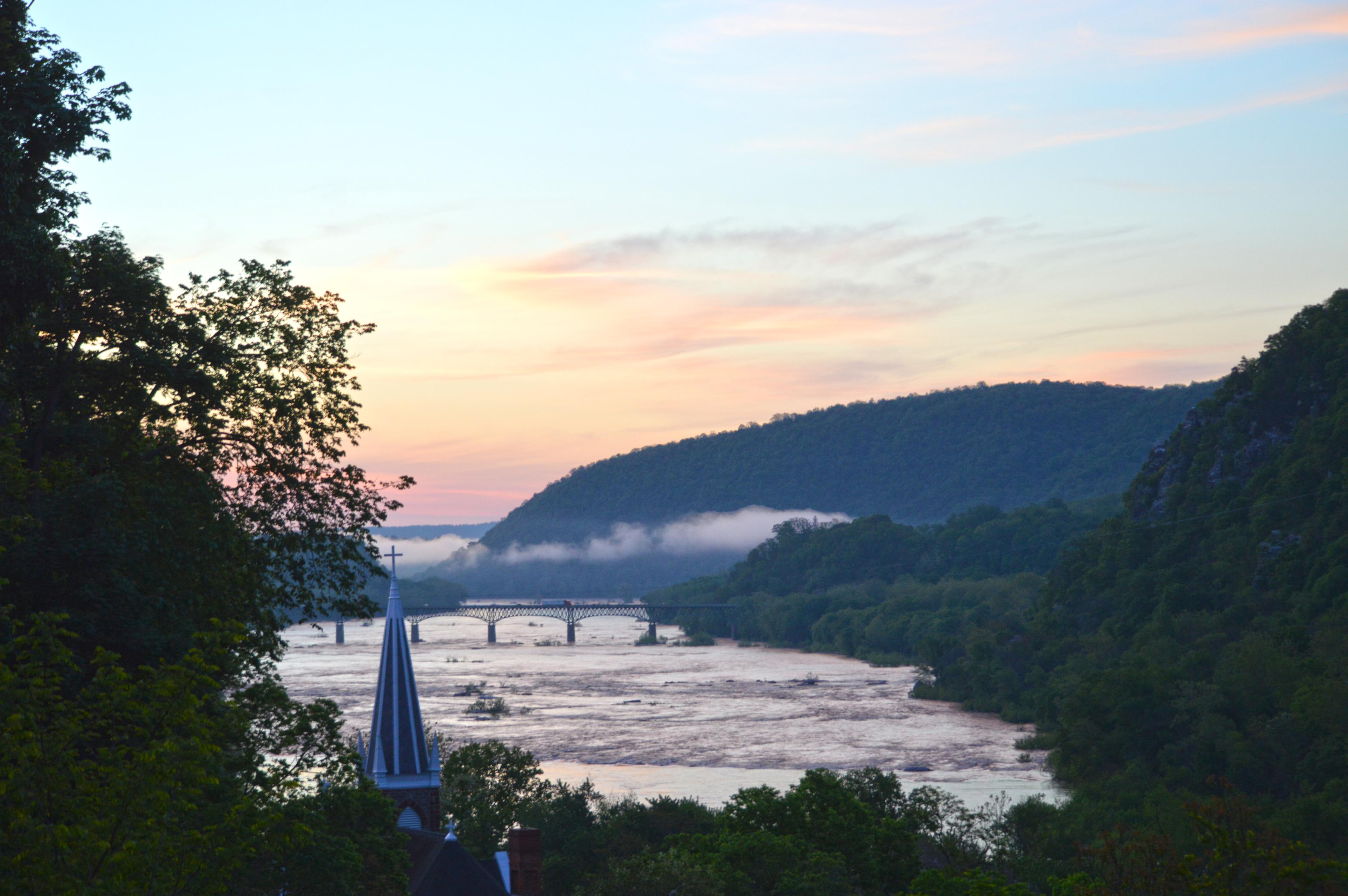 Jefferson Rock view at sunrise; pink in the sky and a light fog over a mountain gap and rivers