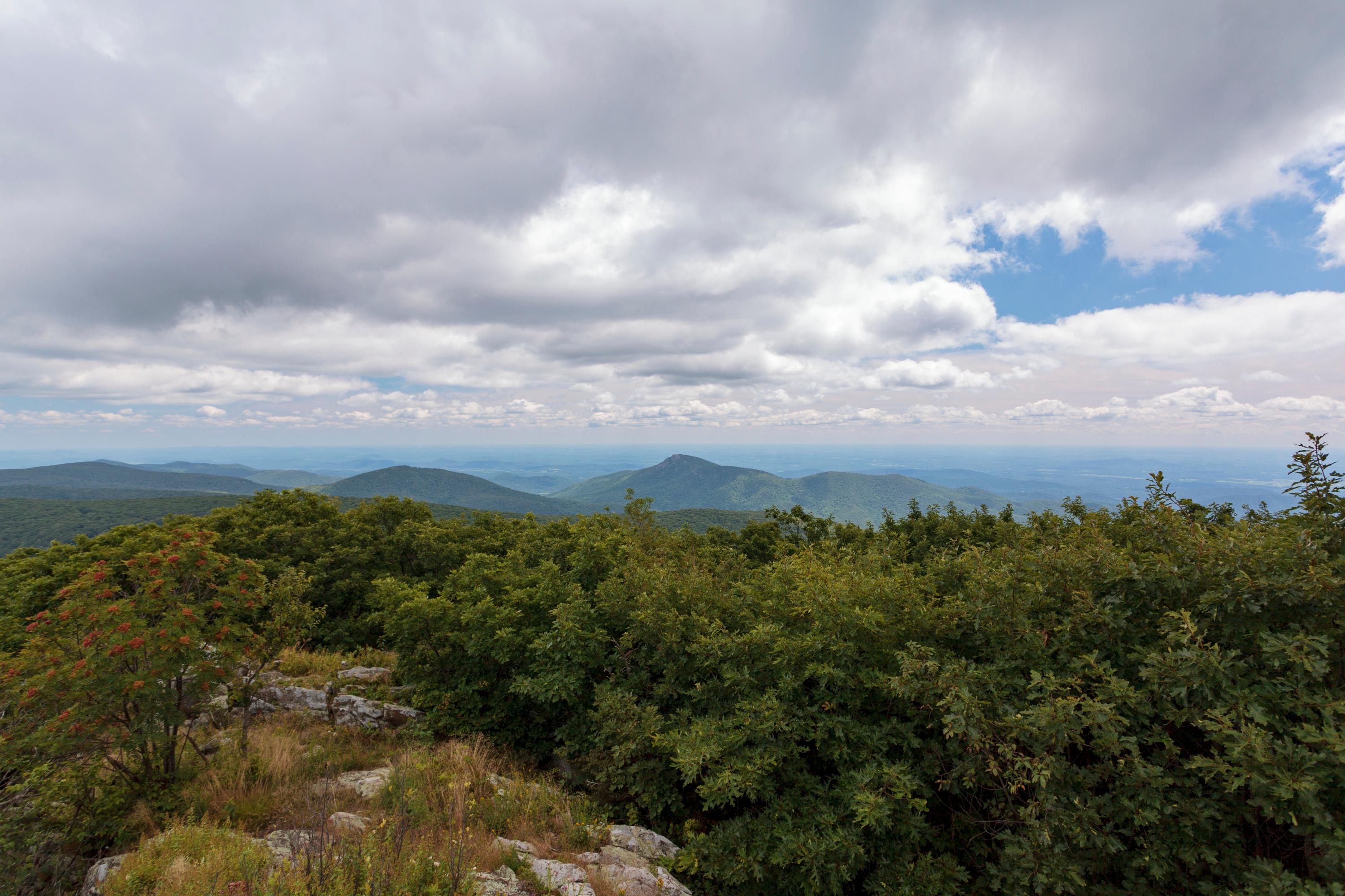 A view from on top of the summit of a mountain.