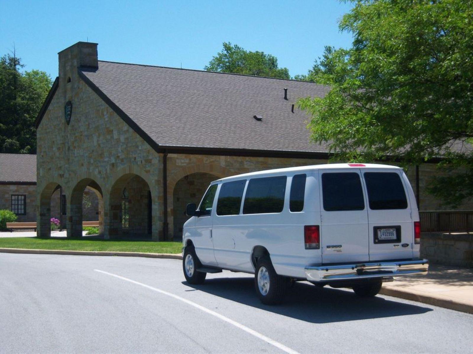 A white van by a stone building.