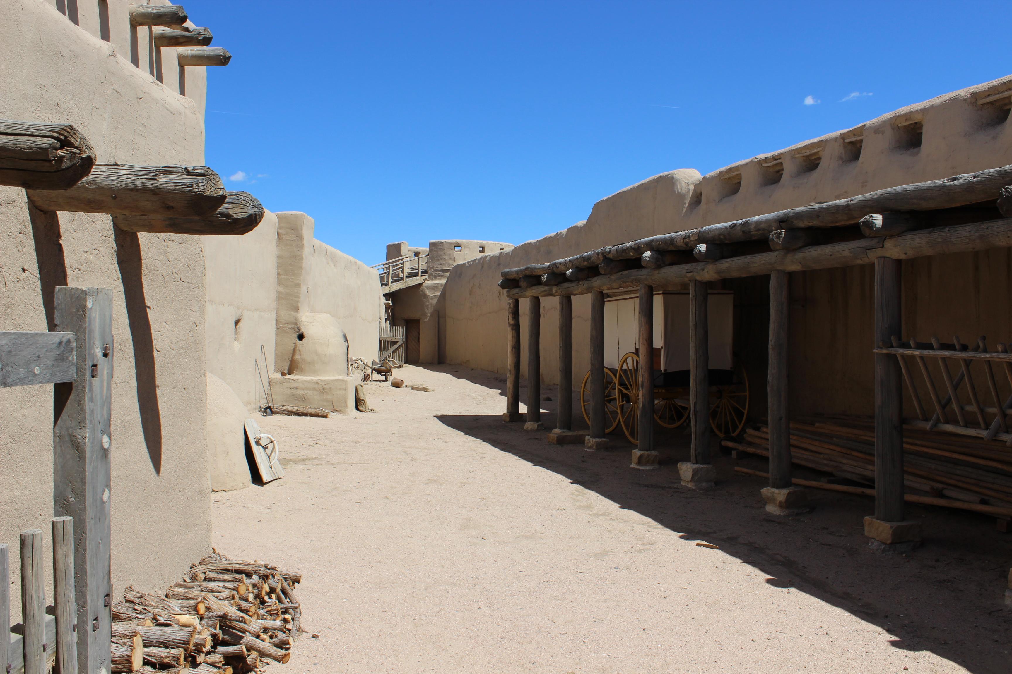 A triangular corral defined by tall adobe walls.