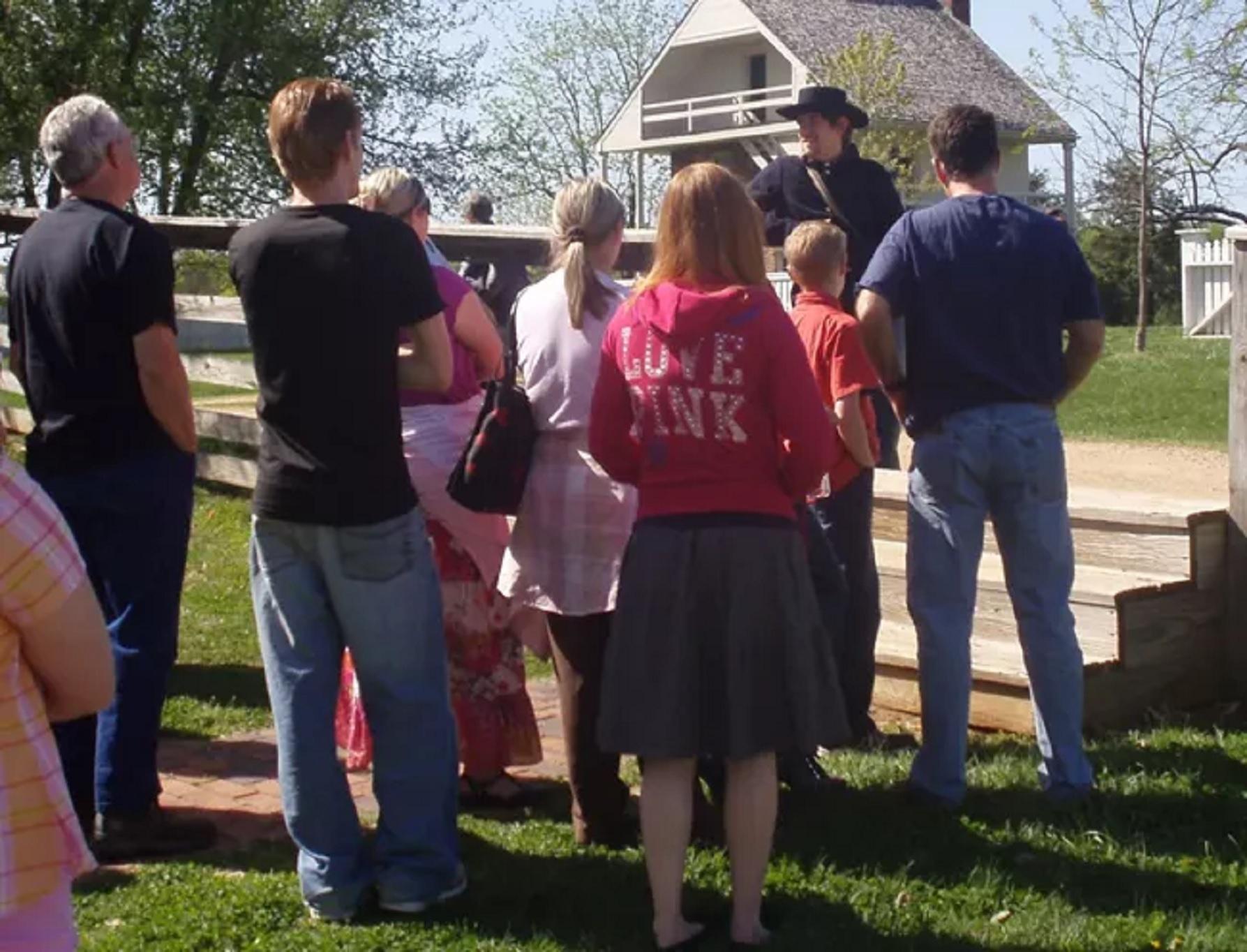 A man in a 1860s soldier uniform talks to visitors.