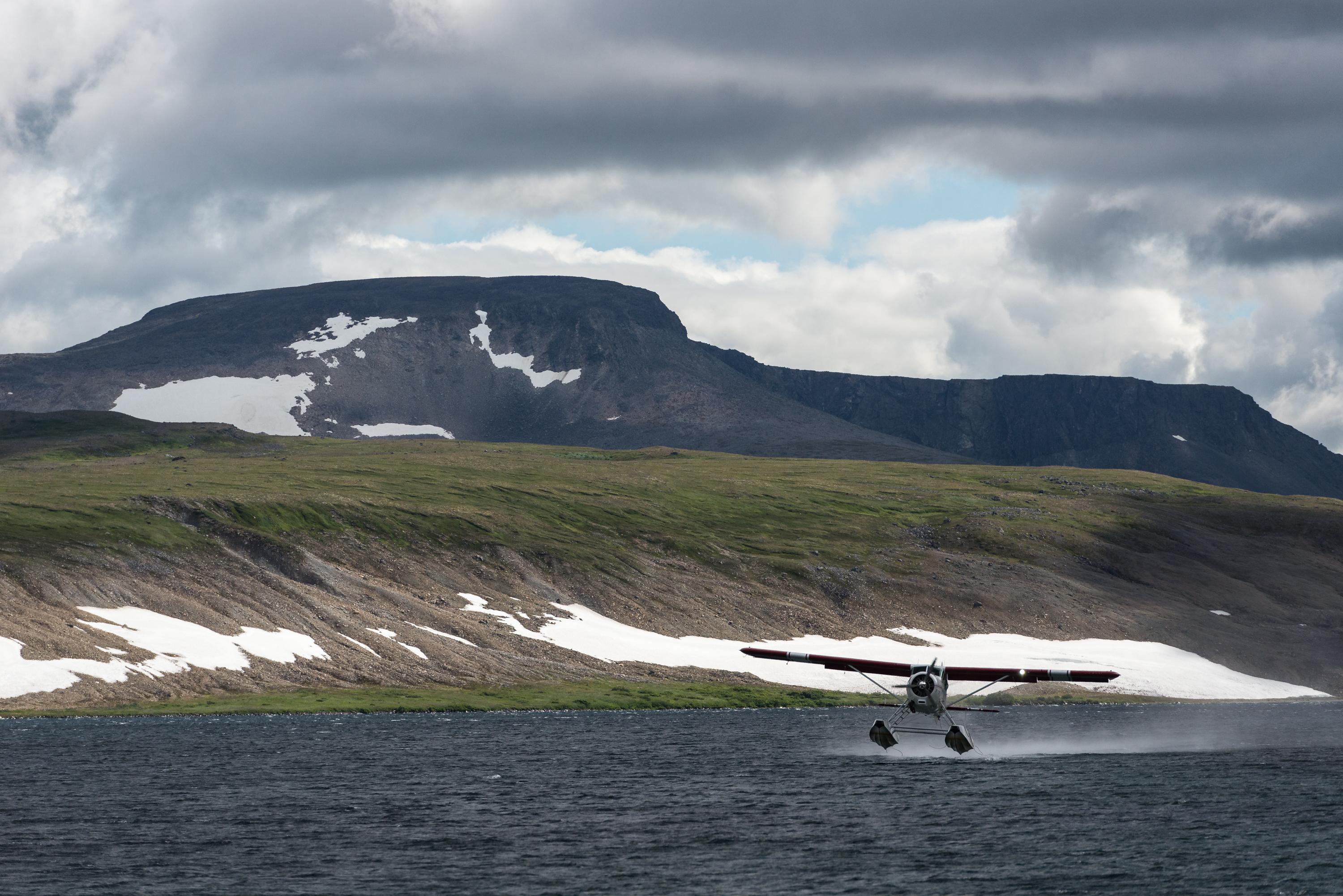 Float plane landing on the water on a cloudy day