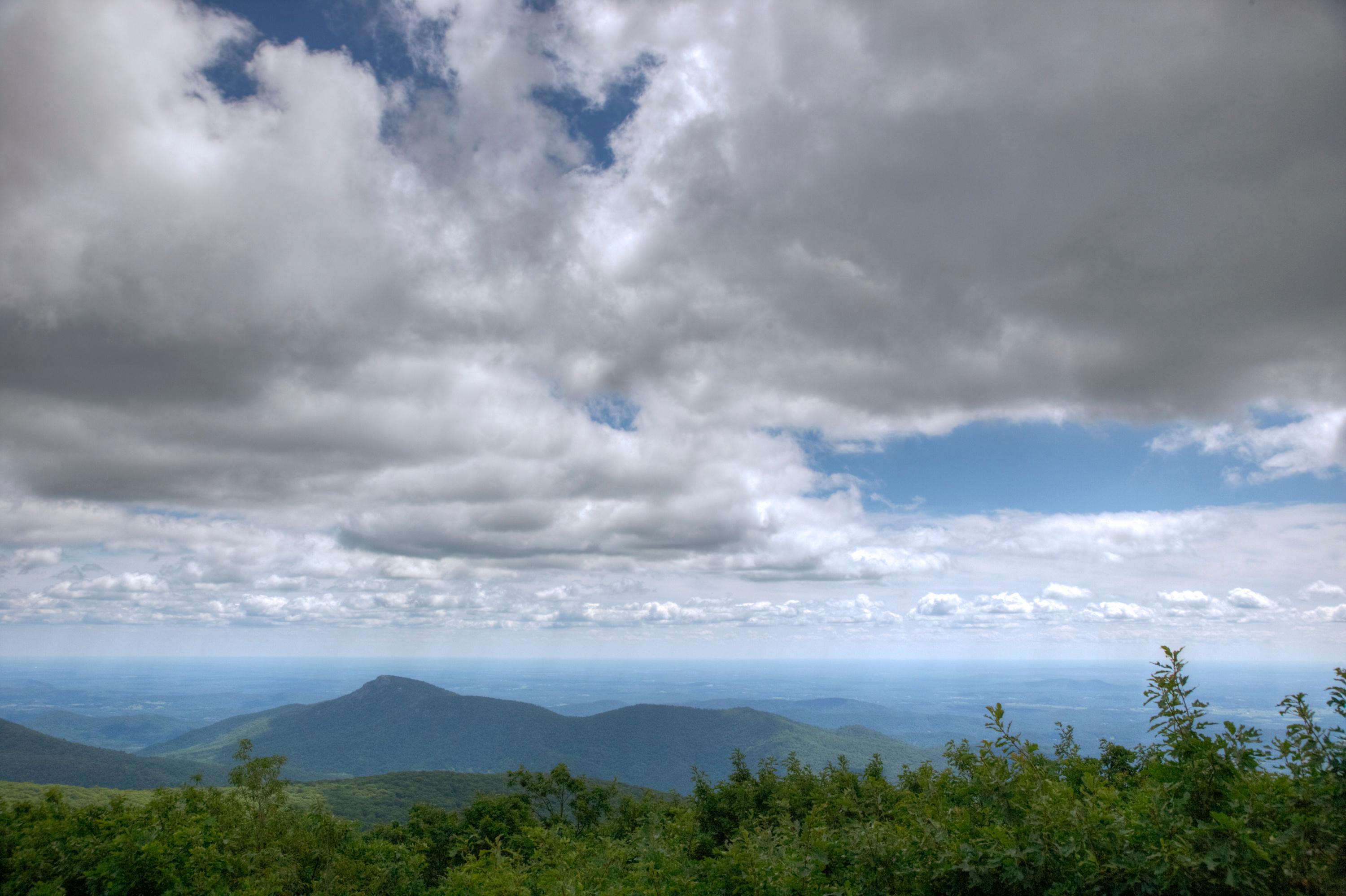 A view from on top of the summit of a mountain.