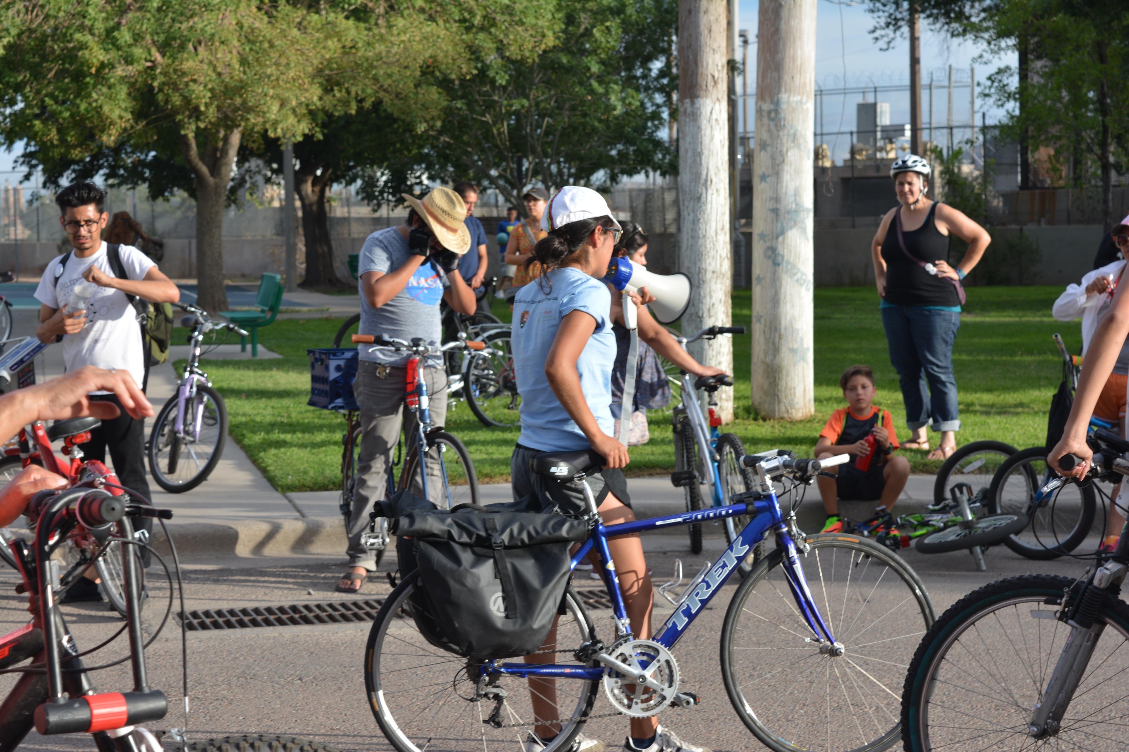 A Chamizal National Memorial intern gives directions to a group of people on bikes.