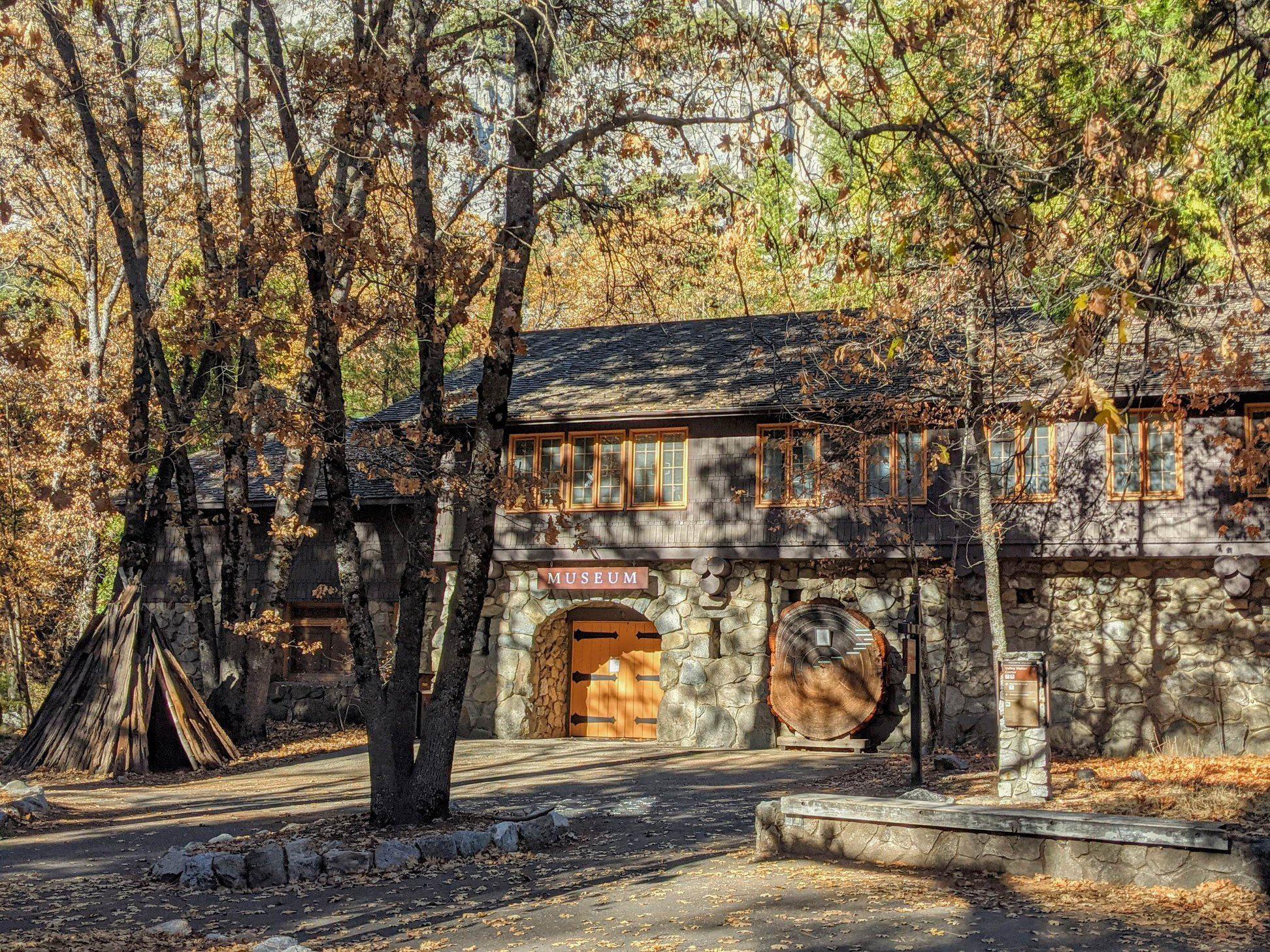 View of front of Yosemite Museum with dappled sunlight in fall.