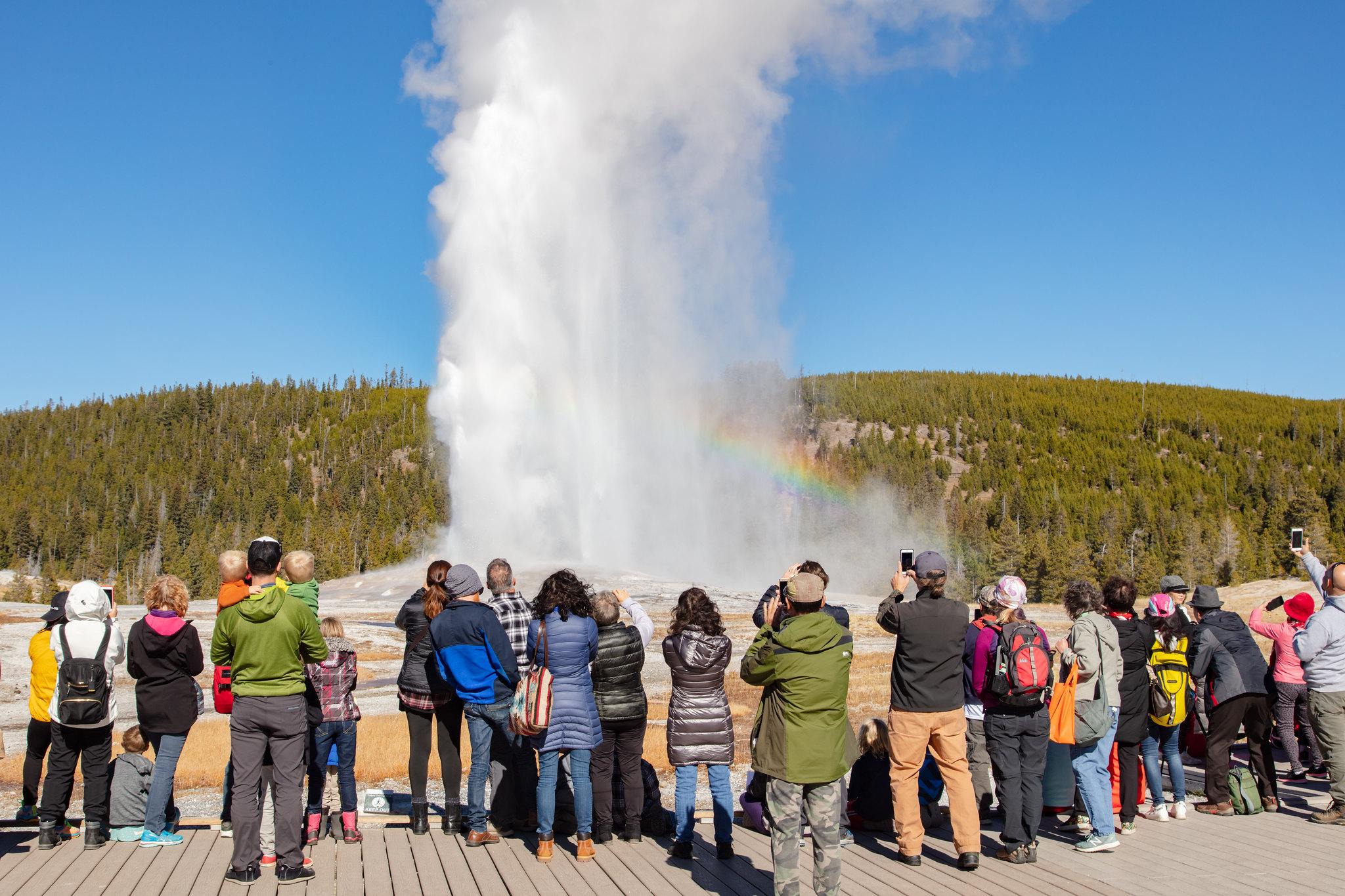 Visitors watch an eruption of Old Faithful Geyser.