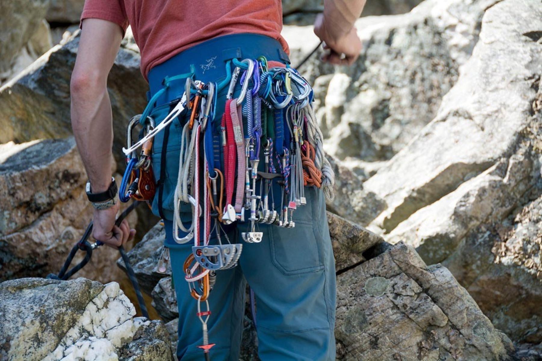 A rock climber wearing multiple harnesses and straps.