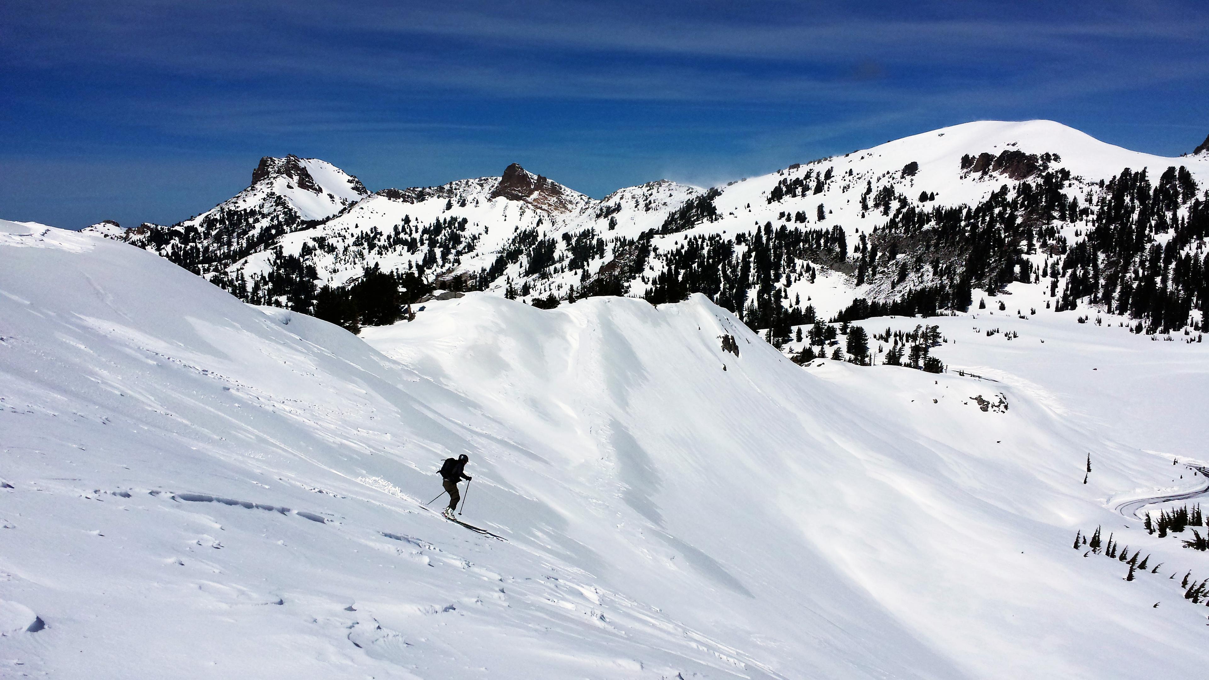 a lone skier on a steep mountain slope