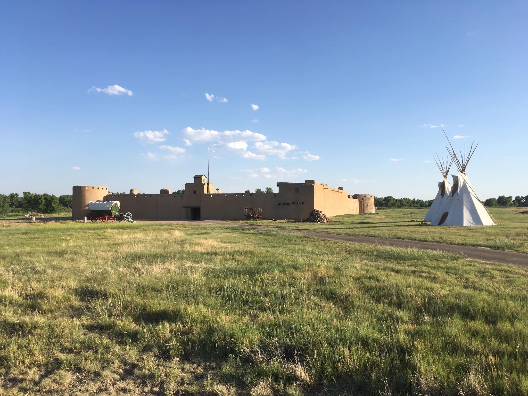 Reconstructed fort at Bent's Old Fort with tipis and wagons in front