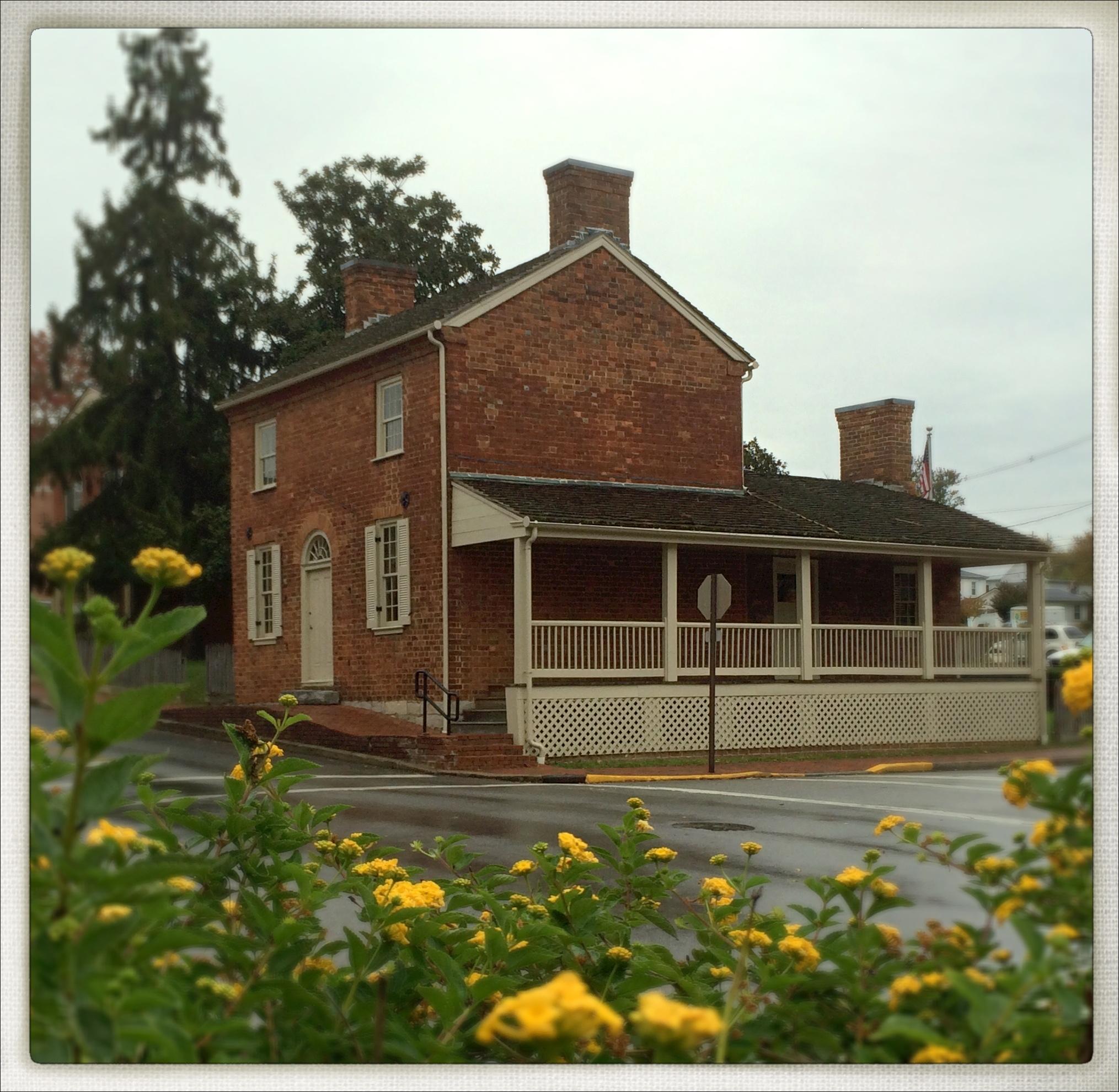 View of Early Home with flowers