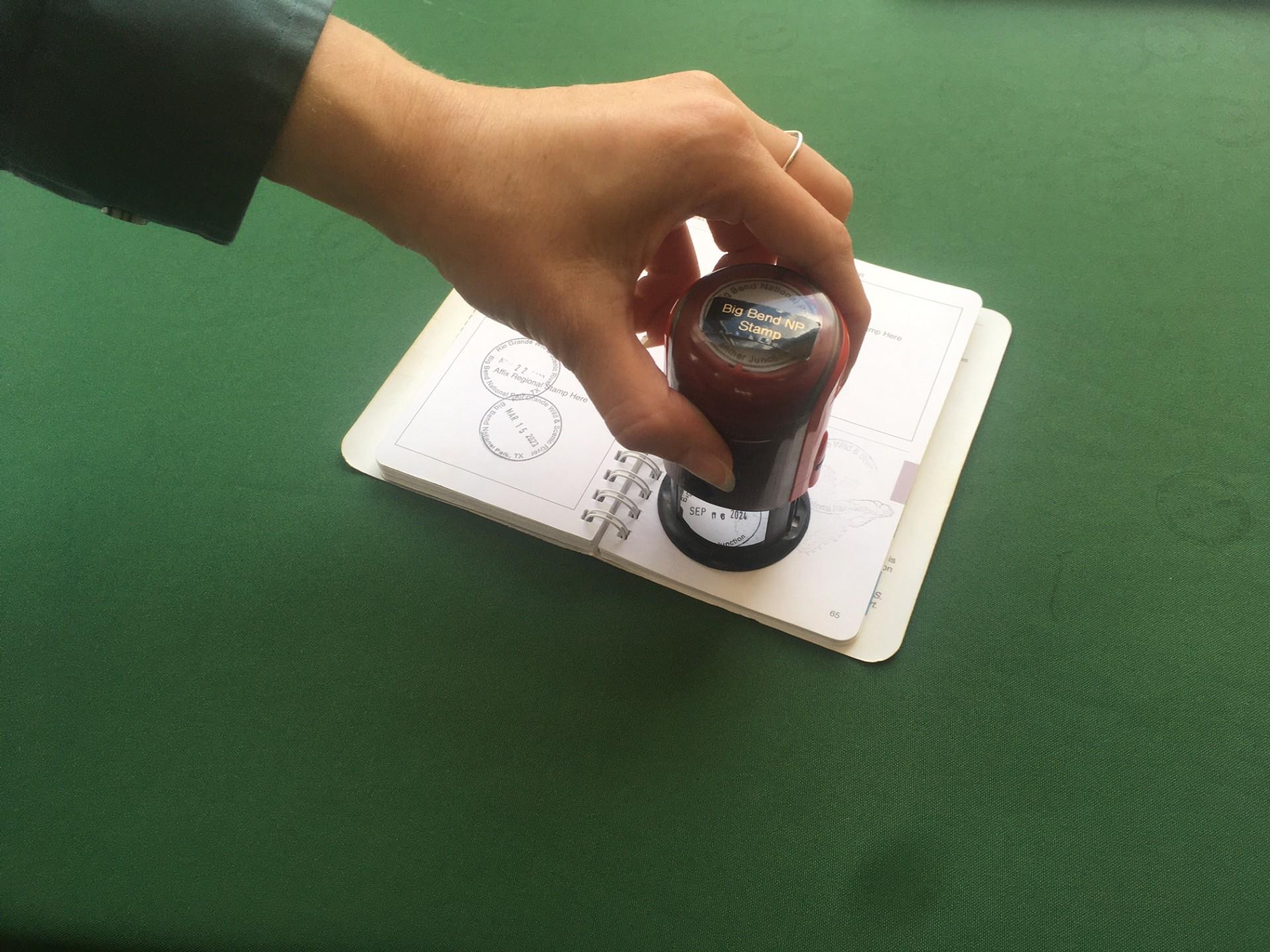 Park visitor stamping their NPS Passport book