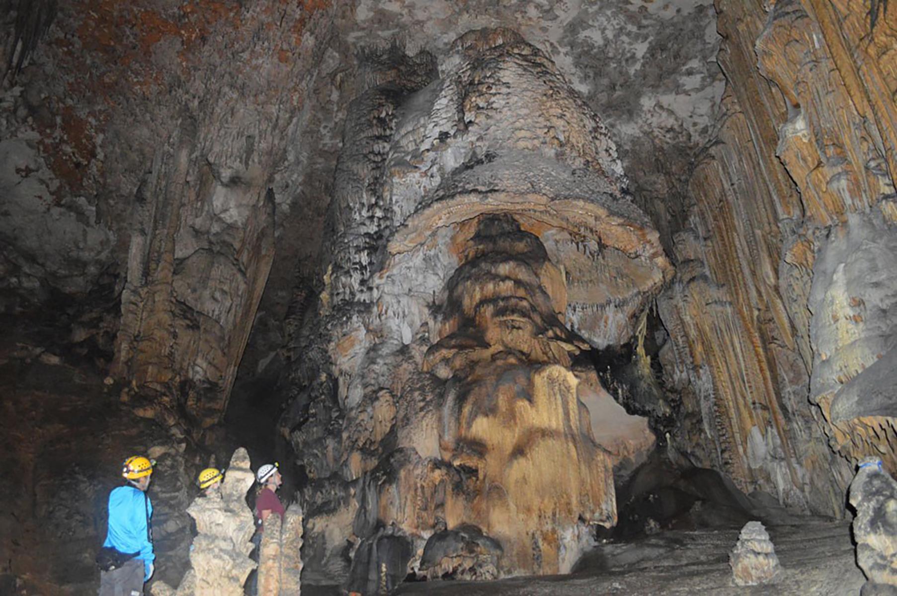 Photo of the Mushroom cave formation with visitors in the Slaughter Canyon Cave.