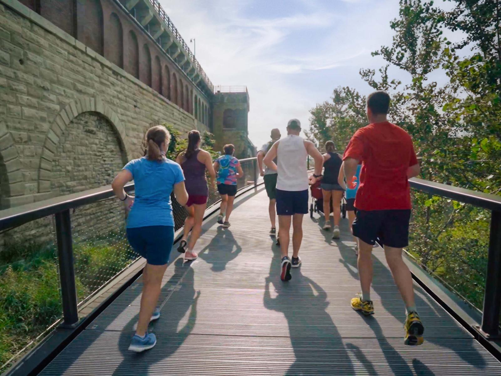 a group of men and women running or jogging along a path