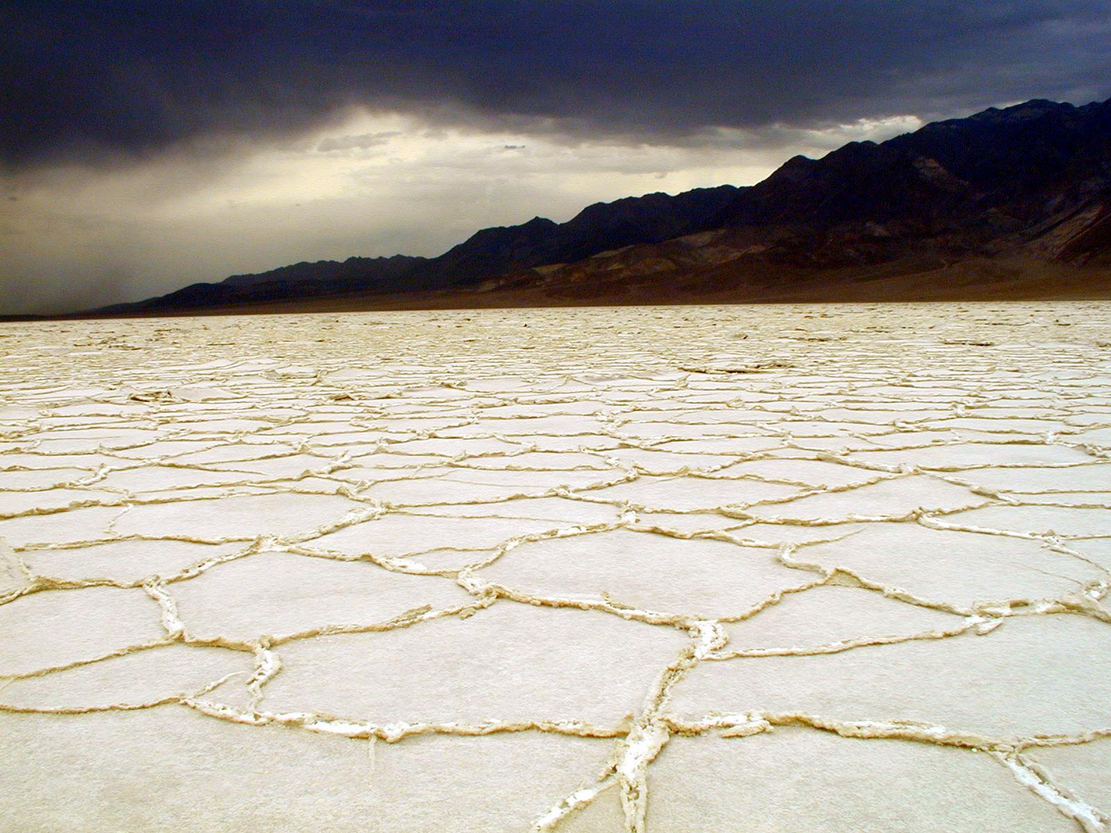 white salt flats with dark gray clouds