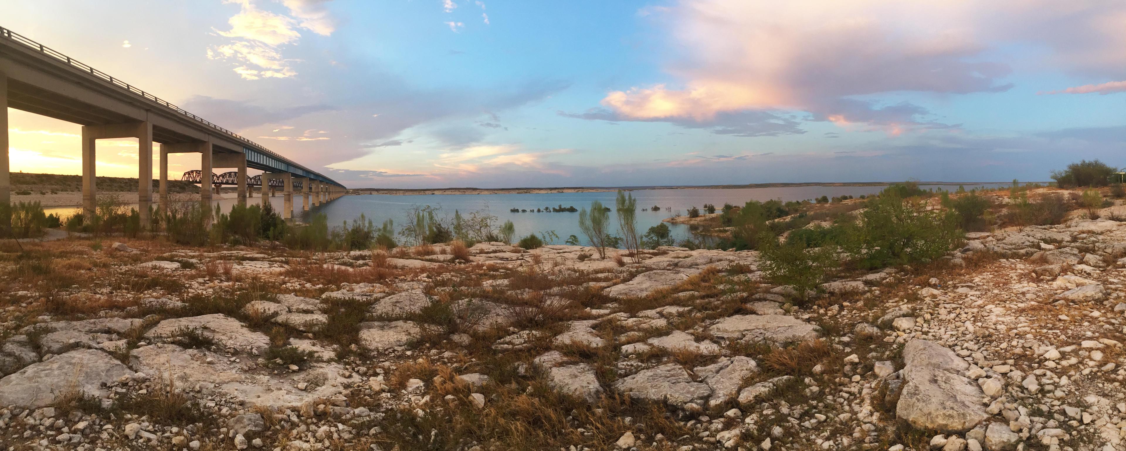 Sunset over Amistad Reservoir with Highway 90 bridge to left of photo going over the reservoir and i