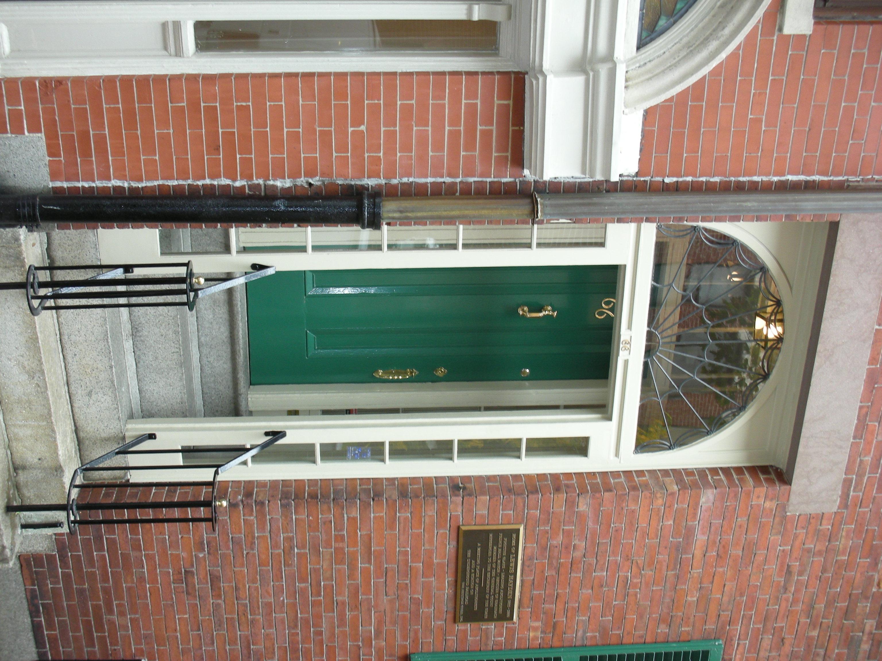 The entrance door into a red brick townhouse on Beacon Hill