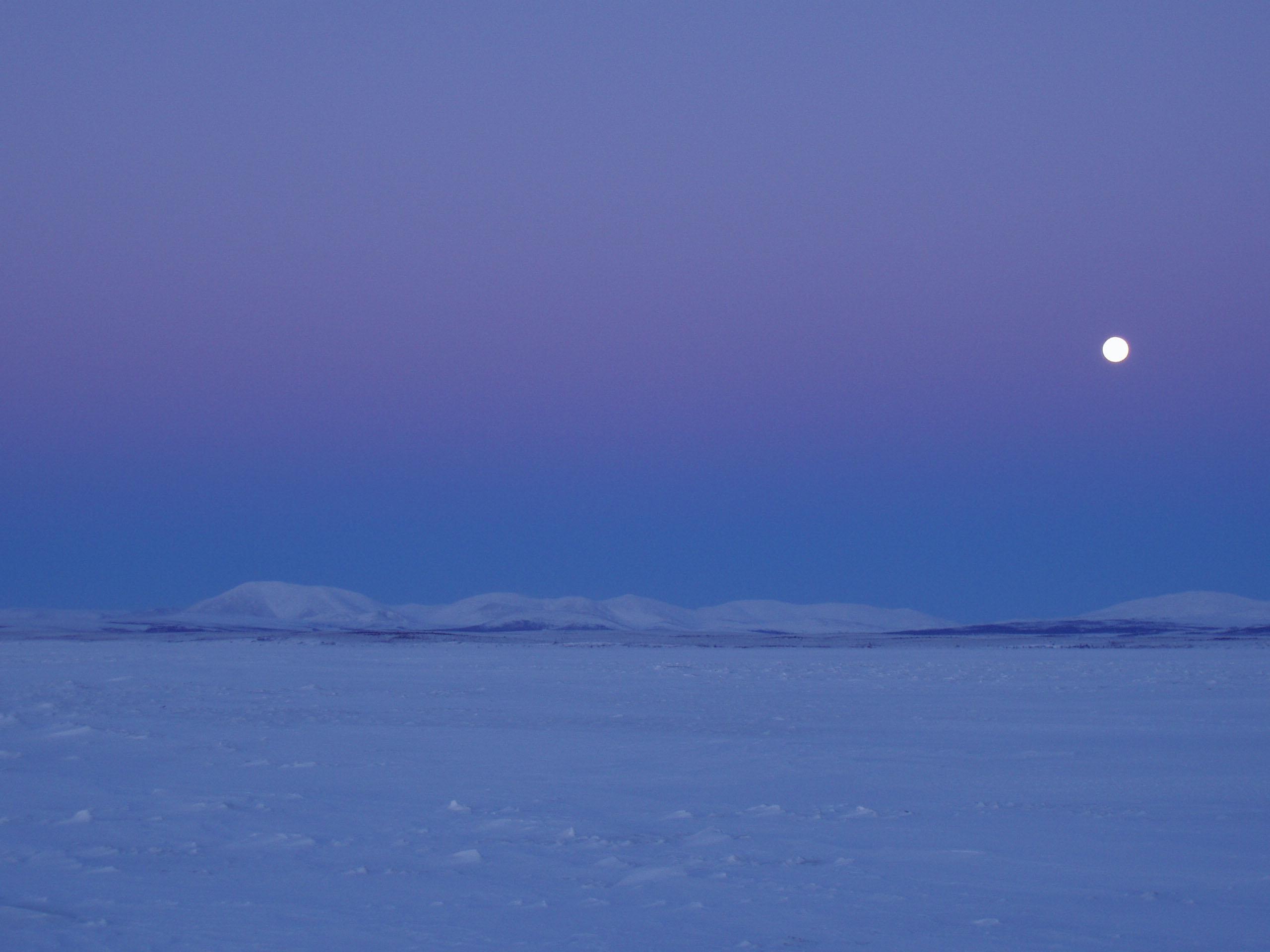 moon over snow covered hills