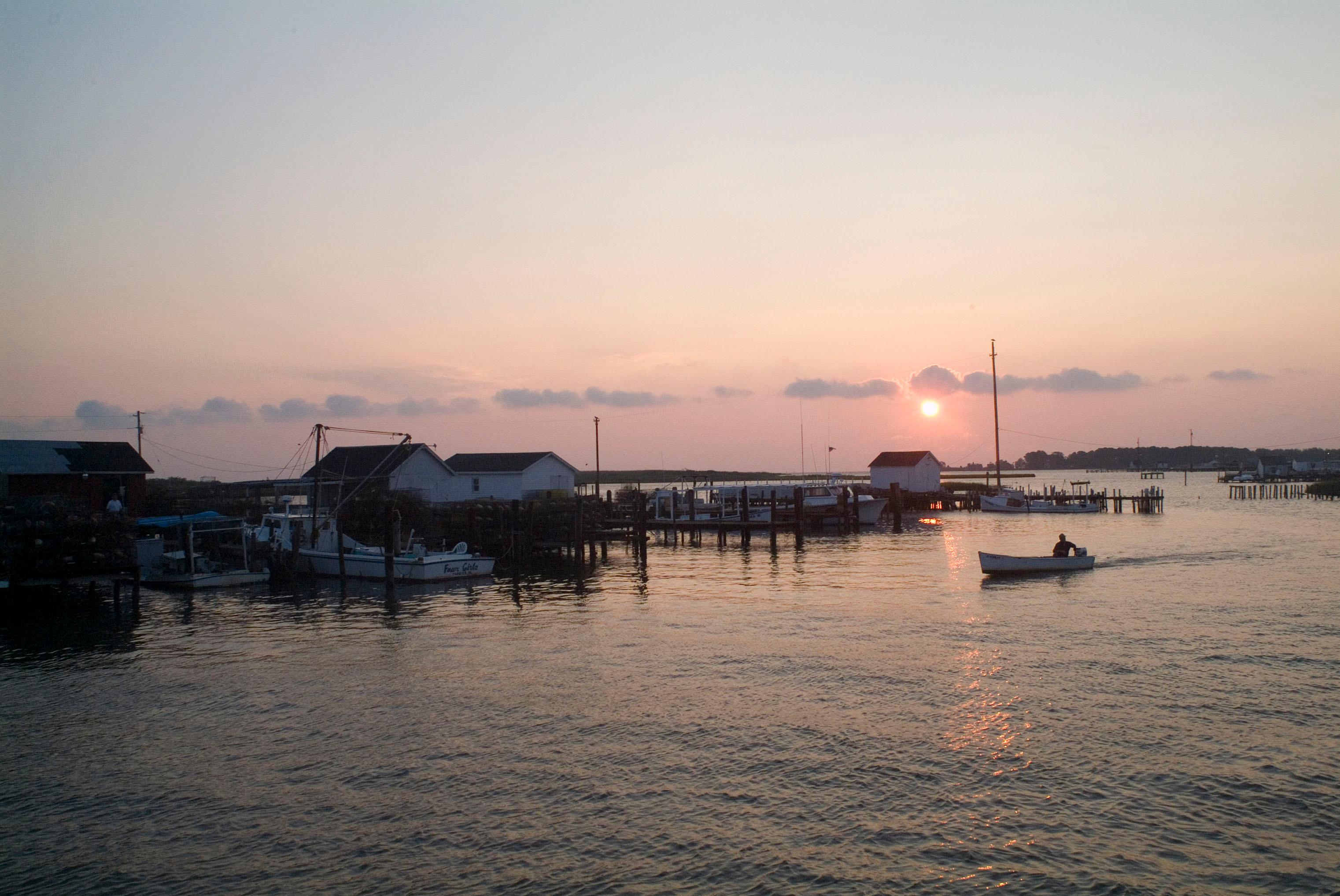 At sunset, a boater returns to the docks used by working watermen at Tangier Island.