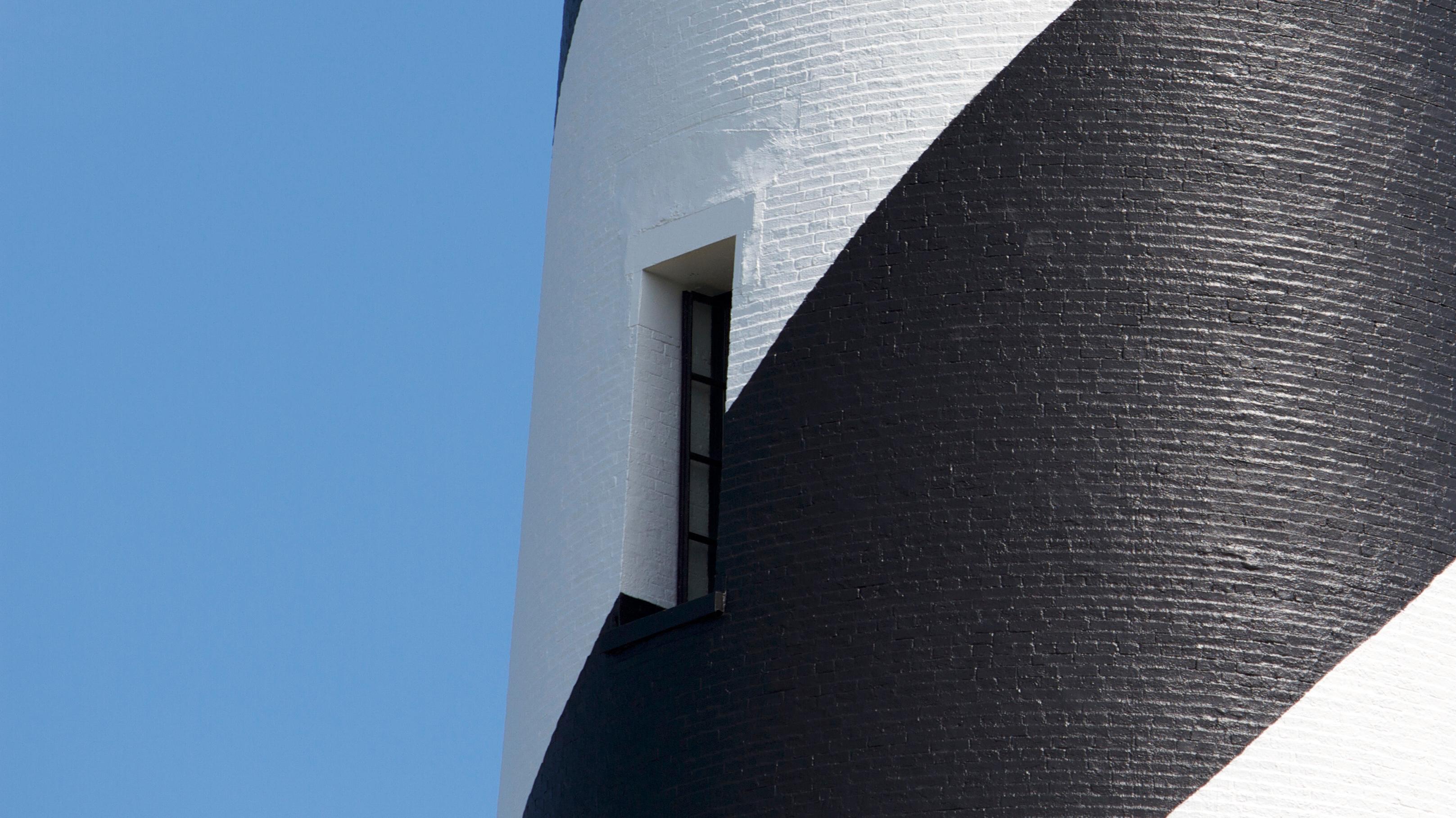 Black and white painting of the brick Cape Hatteras Lighthouse.