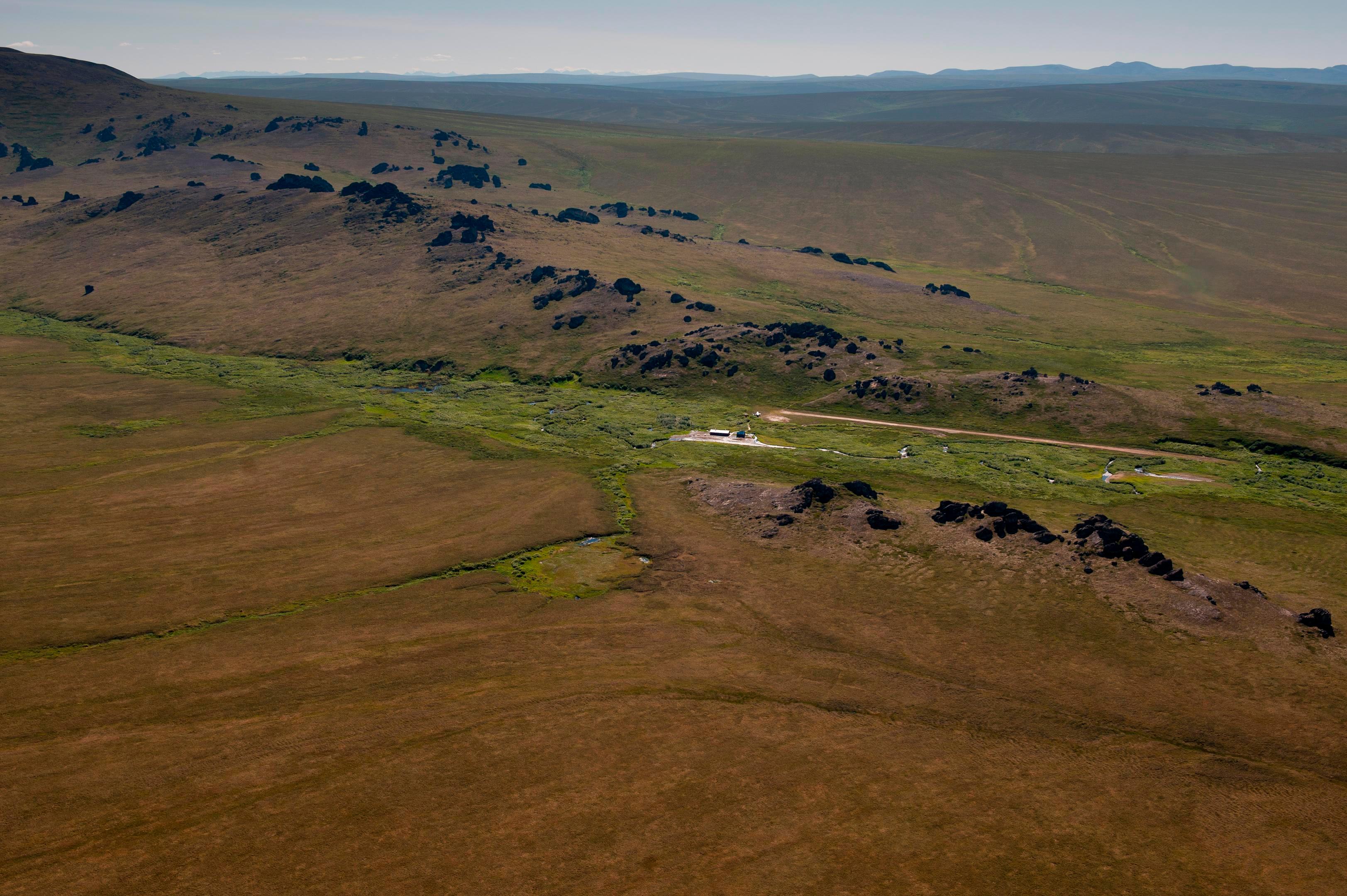 A vast expanse of undulating hills with granite spire jutting from the top.